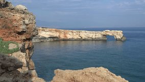 Video of stone arch Kamara and coastal rocks in the sea near Geropotamos beach on Crete, Greece, Rethymno prefecture.
