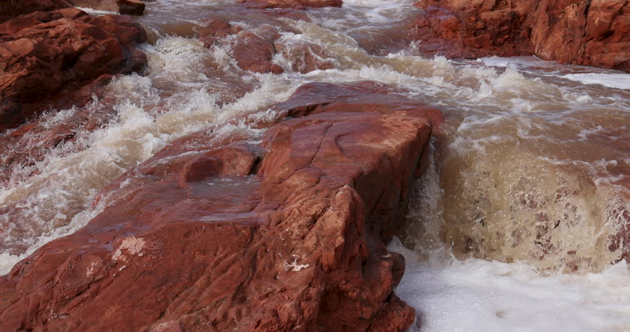 Gunlock reservoir waterfalls red rock Utah slow. State park. Steep red rock landscape flood water from historic snow melt and rain reservoir river. Scenic travel environmental destination.