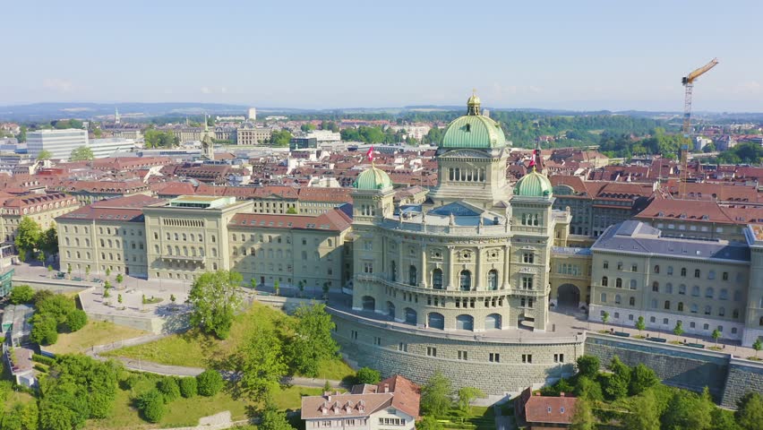Inscription on video. Bern, Switzerland. Federal Palace - Bundeshaus, Historic city center, general view, Aare river. On the mechanical display, Aerial View, Point of interest