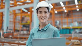 Smiling face of professional engineer woman manager leader holding laptop wearing helmet and looking at camera at manufacturing factory - Powered by Shutterstock - Get 15% off with code: PIKWIZARD15