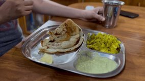 A cinematic footage or video of  selective focus of a fried crispy  food Dosa being eaten by an Indian woman's hand.