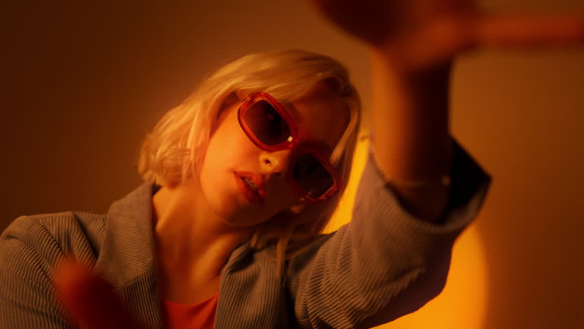 Portrait of fashion woman dancing hands while posing in sunglasses