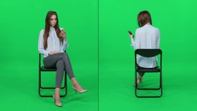 Elegant woman in a light-blue shirt sitting on an office chair, uses a smartphone to check social networks, green background, waiting process, video collage.