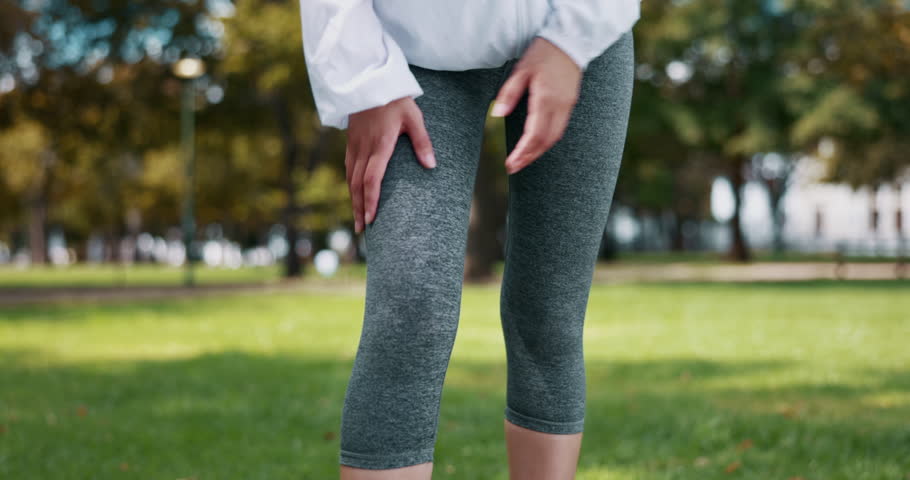Knee pain, injury and hands of woman in a park for fitness, running and exercise while suffering from arthritis. Injured, leg and girl runner training in nature with ache or muscle, problem or issue Royalty-Free Stock Footage #1102165919