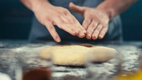 Close-up of a woman's hands making a pie form out of dough. Delicious sweet pastries and cakes baked by the chef. High quality 4k footage