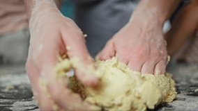 Close-up slow motion video of female hands kneading dough. Mother and children prepare bread for baking at home. High quality 4k footage