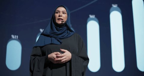 Business Expo Stage: Famous Inspirational Speaker From Gulf Region Talking about Technology, Science, Success, Productivity. Tech Industry Businesswoman in Traditional Arab Hijab Giving a Presentation Arkistovideo