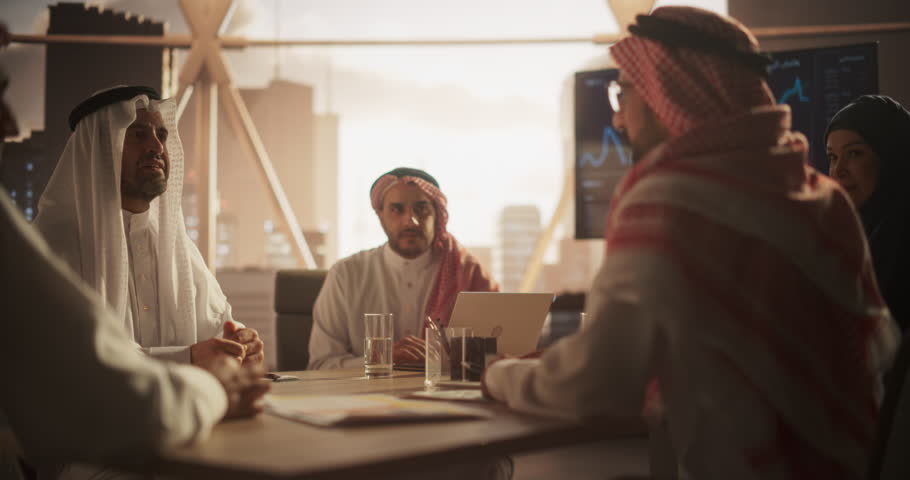 Muslim Businesspeople Closing a Business Deal at a Corporate Modern Office. Two Men in Traditional Clothes Shake Hands and Celebrate Successful Partnership. Saudi, Emirati, Arab Office Concept Royalty-Free Stock Footage #1102169063