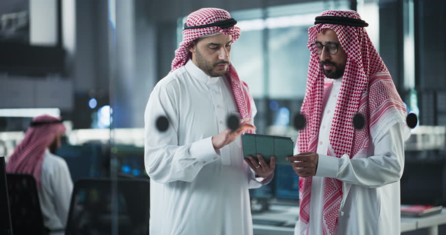 Two Multiethnic Arab Colleagues Having a Conversation While Busy Working on a Software Development Project. Engineer Talking with a Middle Eastern Project Manager, Using Tablet Computer in Office Royalty-Free Stock Footage #1102169155
