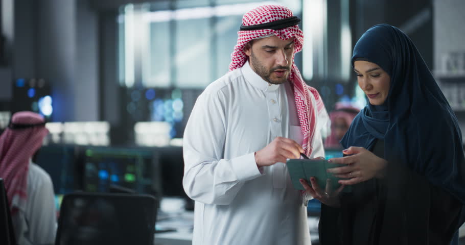 Team of Two Diverse Specialists Use Tablet Computer. Having a Conversation on a Cybersecurity Project. Empowered Young Middle Eastern Male and Female Work on Digital E-Commerce Startup Business Royalty-Free Stock Footage #1102169231