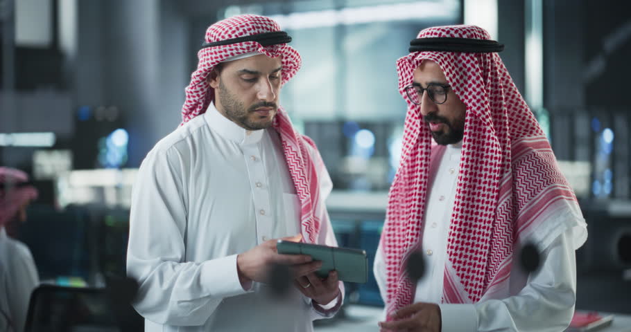 Two Young Muslim Software Engineers Use Tablet Computer to Discuss a Technological Project in a Modern Industrial Office. Arab Scientists Work in Research and Development Center Royalty-Free Stock Footage #1102169237