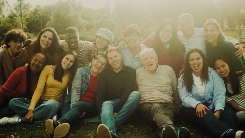 Happy multigenerational people having fun sitting on grass in a public park Royalty-Free Stock Footage #1102172179