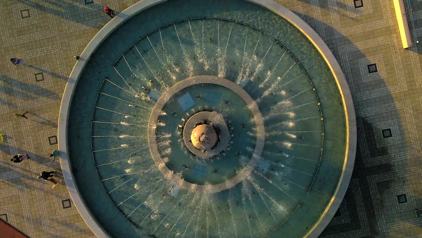 Air fountain from top to bottom 4k. People walk along the summer embankment.