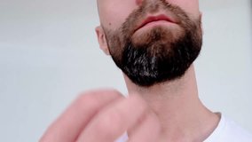 close-up part of the face, bearded young man 30 years old touches his chin with his hand, concept daily routine beard care, healthy lifestyle,