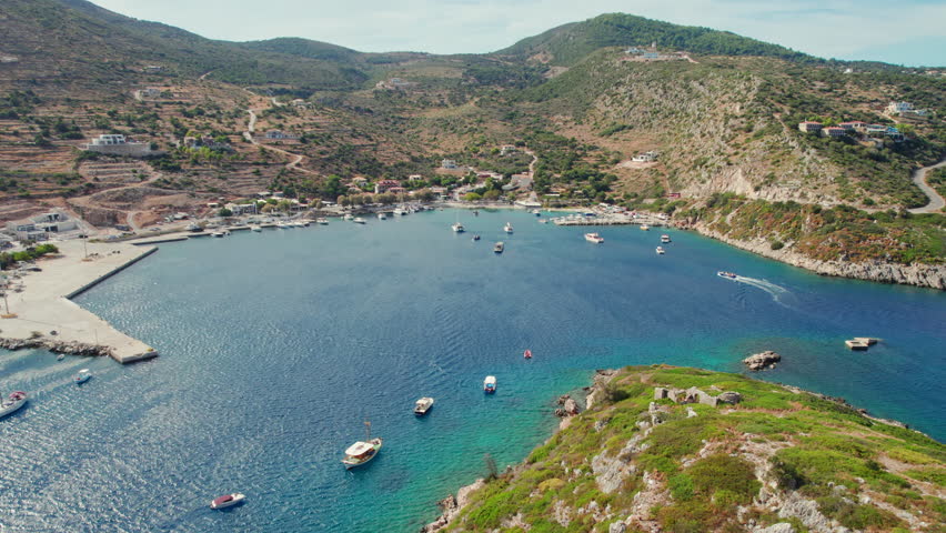 Agios Nikolaos fishing village on Zakynthos island, Ionian sea, Greece. Aerial view of boats in beautiful bay with turquoise water in small Greek Agios Nikolaos port in Zante. Orbit shot