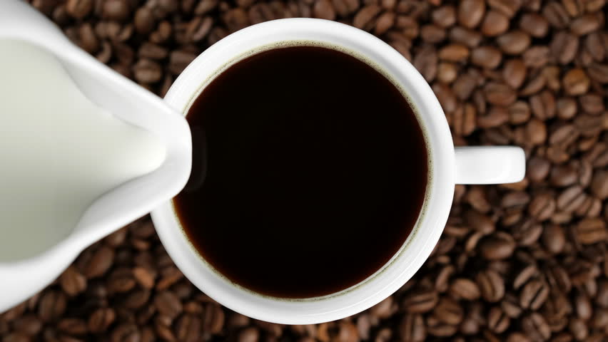 Pouring milk in coffee cup, top view Royalty-Free Stock Footage #1102178569