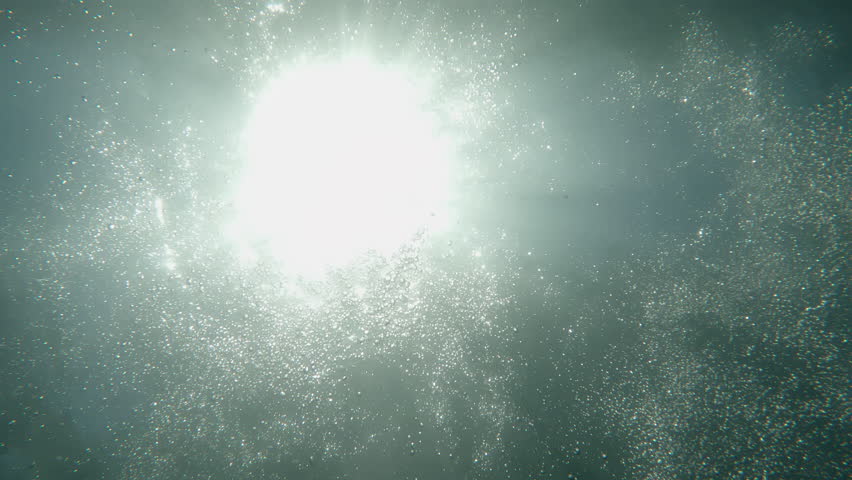 Beautiful sunshine seen through water with bubbles like a miracle. Texture of underwater motions and ray of sun through surface of sea. Peaceful natural background. Film grain pixel texture. Brilliant Royalty-Free Stock Footage #1102181457