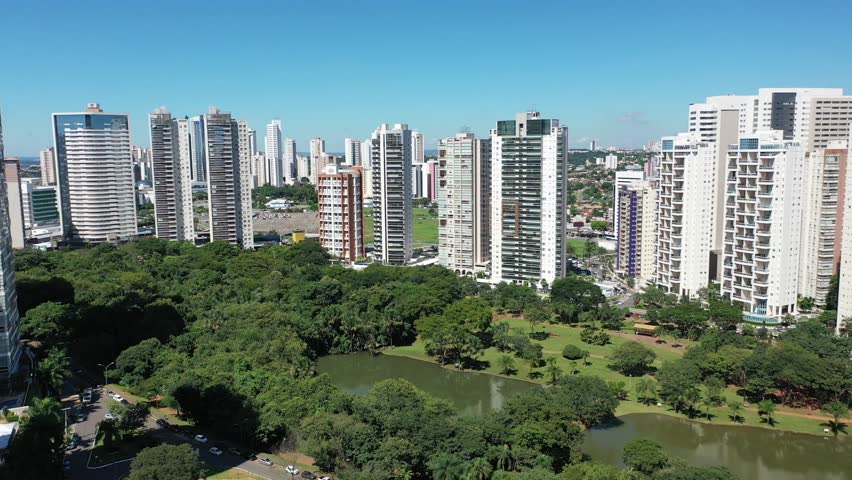 Panoramic video of Flamboyant park with lakes and tropical trees surrounded by modern residential buildings. Goiania, Goias, Brazil 