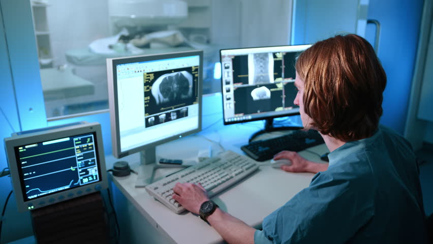 A behind view of veterinarian looking at the magnetic resonance image. He looks focused on his work. He is writing something down. High quality 4k footage Royalty-Free Stock Footage #1102189225
