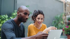 Video of a cute multiethnic couple using computer while talking in a garden of a coffee shop - Powered by Shutterstock - Get 15% off with code: PIKWIZARD15