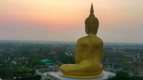 aerial hyperlapse colorful sky in sunrise at golden big buddha a popular landmark in Thailand.
video 4K Nature video High quality footage for worship and travel concept.
 rice field background.
