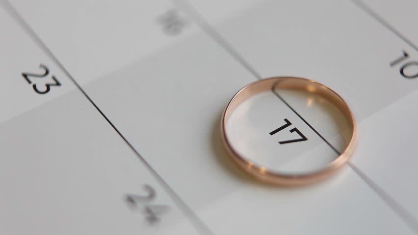 The wedding ring lies on the calendar date of the 17th. A man or woman draws a heart with a red marker on a calendar. Round date of acquaintance or wedding. Royalty-Free Stock Footage #1102191867
