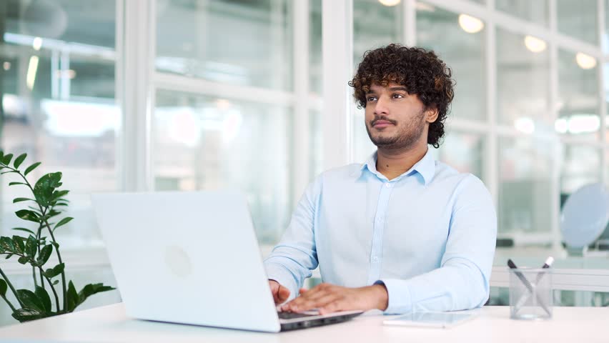 Young developer meditating with closed eyes during a break while sitting at the workplace in the office. A calm worker rests and relaxes. The male takes a break to relieve stress. Feels peace of mind Royalty-Free Stock Footage #1102192833