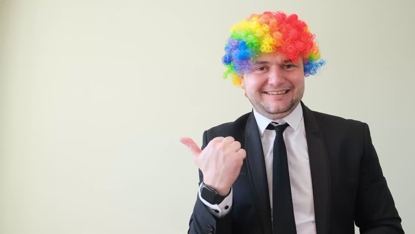 Cheerful smiling man in business suit and mask with dyed hair showing thumb up. 