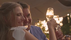 LJUBLJANA, SLOVENIA, APRIL 2023: LENS FLARE, CLOSE UP: Smiling bride and groom with raised glasses of champagne. Golden sunbeams shine through champagne glasses while toasting at wedding reception. - Powered by Shutterstock - Get 15% off with code: PIKWIZARD15