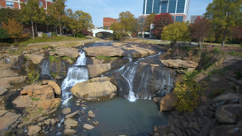 Reedy River Waterfalls in downtown of Greenville city in South Carolina. Falls Park riverwalk at Liberty bridge. American travel destination.