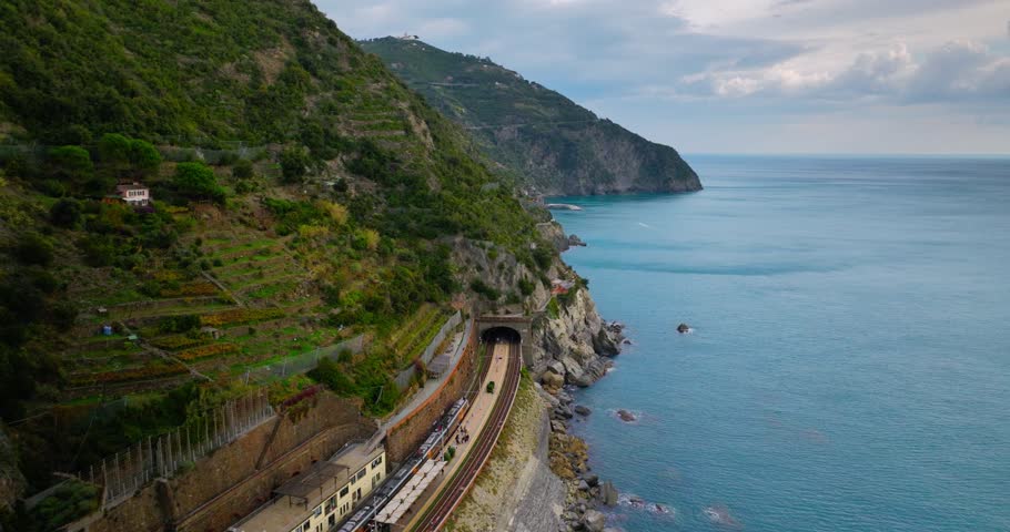 Train at station Manarola Cinque Terre Italy Liguria famous historic town of colorful houses on the cliffs of Mediterranean Sea Drone view Royalty-Free Stock Footage #1102203807