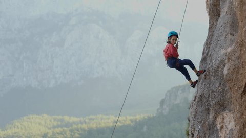 child climber descends from the cliff. a cheerful boy descends from the route down in slow motion. Outdoor sports. children's sports. The concept of extreme sports and safety in the mountains. Vídeo Stock