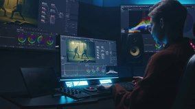Female editor uses color grading control panel, edits video, makes movie color correction on computer and tablet in studio. Film footage and RGB wheels on monitor. Big screens with program interface.