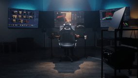 The editor works in studio on computer, edits video, makes color correction for movie post production. Big screens showing color grading program interface with film footage, RGB graphic and levels.