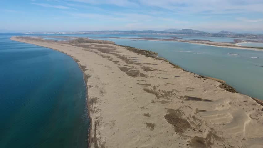 Aerial view of sandy longshore drift sands between sea and lagoon.