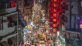 Timelapse view of traffic on Main Bazaar street in the vibrant Paharganj Market at night in Central Delhi, India, zoom out. - Powered by Shutterstock - Get 15% off with code: PIKWIZARD15