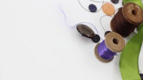 Multi-colored threads and sewing devices on a white background. 4K.