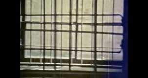 Close up, prison bars in jail building. Lock room cell for detention of prisoners. Lattice on windows. Criminal, incarceration concept. Vintage color film archive. Retro Vilnius Lithuania 1980s