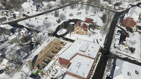Aerial footage showing the construction near Patten Free Library in Bath, ME, snow covered ground and building, forward motion