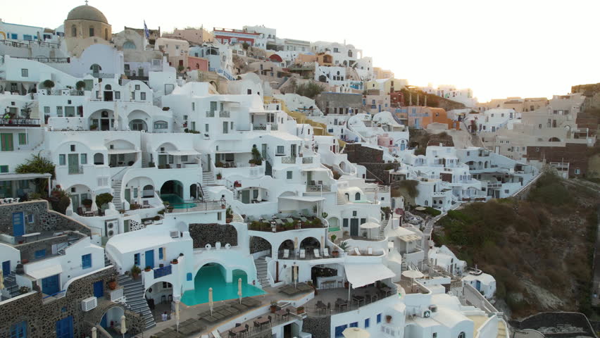 Santorini Island, Greece. Drone Shot of Luxury Resort Villas, White Facades, Blue Doors and Swimming Pools