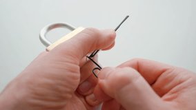 Man picking a lock with paper clips. Lock picking demonstration. Close up