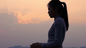 Silhouette of woman   praying over beautiful sunrise background, Video 4k slow motion.
