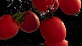 ripe juicy harvest of cherry tomatoes falls into the water with air bubbles on a dark background, close-up - Powered by Shutterstock - Get 15% off with code: PIKWIZARD15