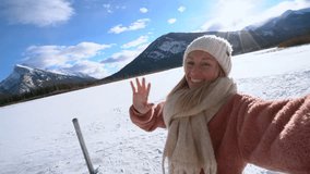Young woman taking cool selfie during a winter vacations in the mountains. Female surrounded by nature 