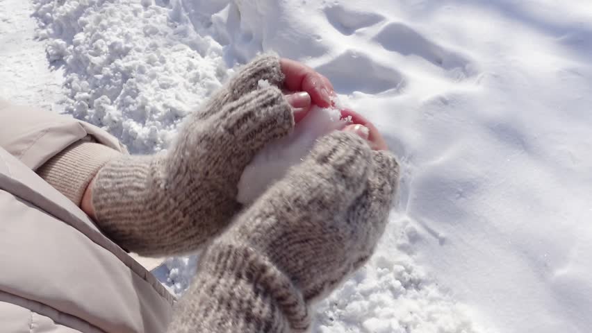 Woman's Hands in Knitted Winter Mittens Making Snowball on a Sunny Snowy Day. Close-up, Slow Motion. Winter Active Games, Playing and Having Fun concept. | Shutterstock HD Video #1102233091