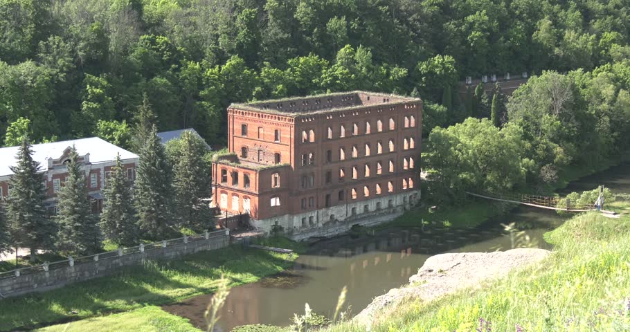 4K summer morning aerial video of mill building ruins by the river