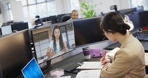 Diverse business people having video call and using laptop with digital chat on screen in office. Business, finances and digital interface.