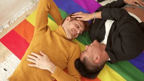 Happy gay couple lying on top of a lgbt flag