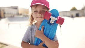 child with skateboard. girl in a red cap with a skateboard on the playground portrait. skateboarder child close-up outdoors sun glare. kid skateboarder lifestyle looking at the camera - Powered by Shutterstock - Get 15% off with code: PIKWIZARD15