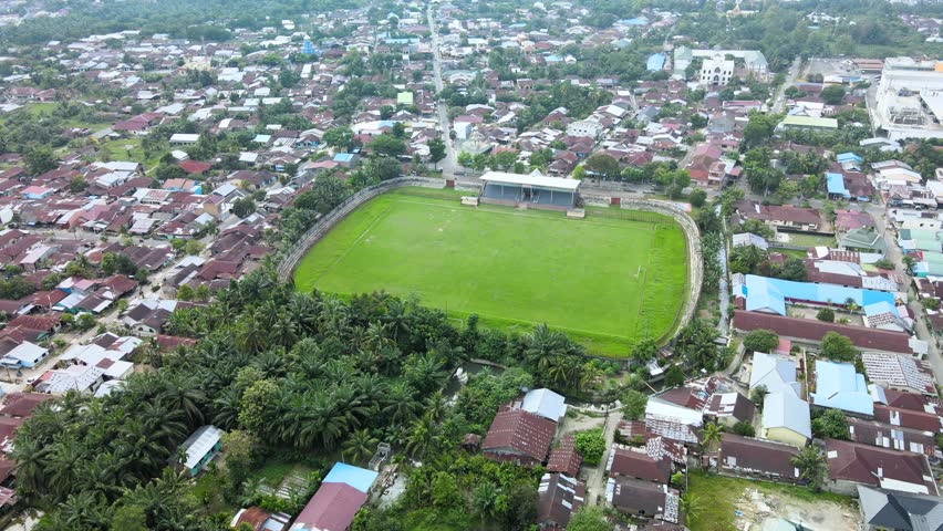 Aerial footage of a stadium in the middle of the city, taken with small descending motion with a drone